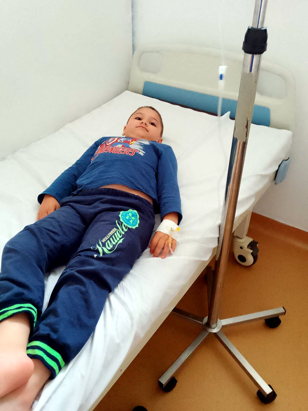 Ianis, băiat de 8 ani, pe patul de spital cu perfuzie în mână
